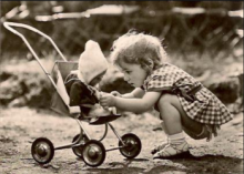 Bild: ein Kind kniet vor einem Puppenwagen und spielt
