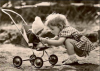 Bild: ein Kind kniet vor einem Puppenwagen und spielt